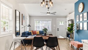A modern kitchen with a dining table, chairs, a ceiling fan, and a clock on the wall. - Historic Cottage Walk to Downtown St Augustine Free Parking Sleeps 4 (St. Augustine)