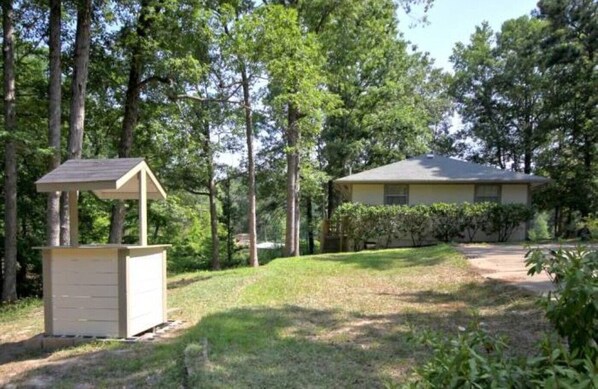 A house with a small shed in a wooded area.