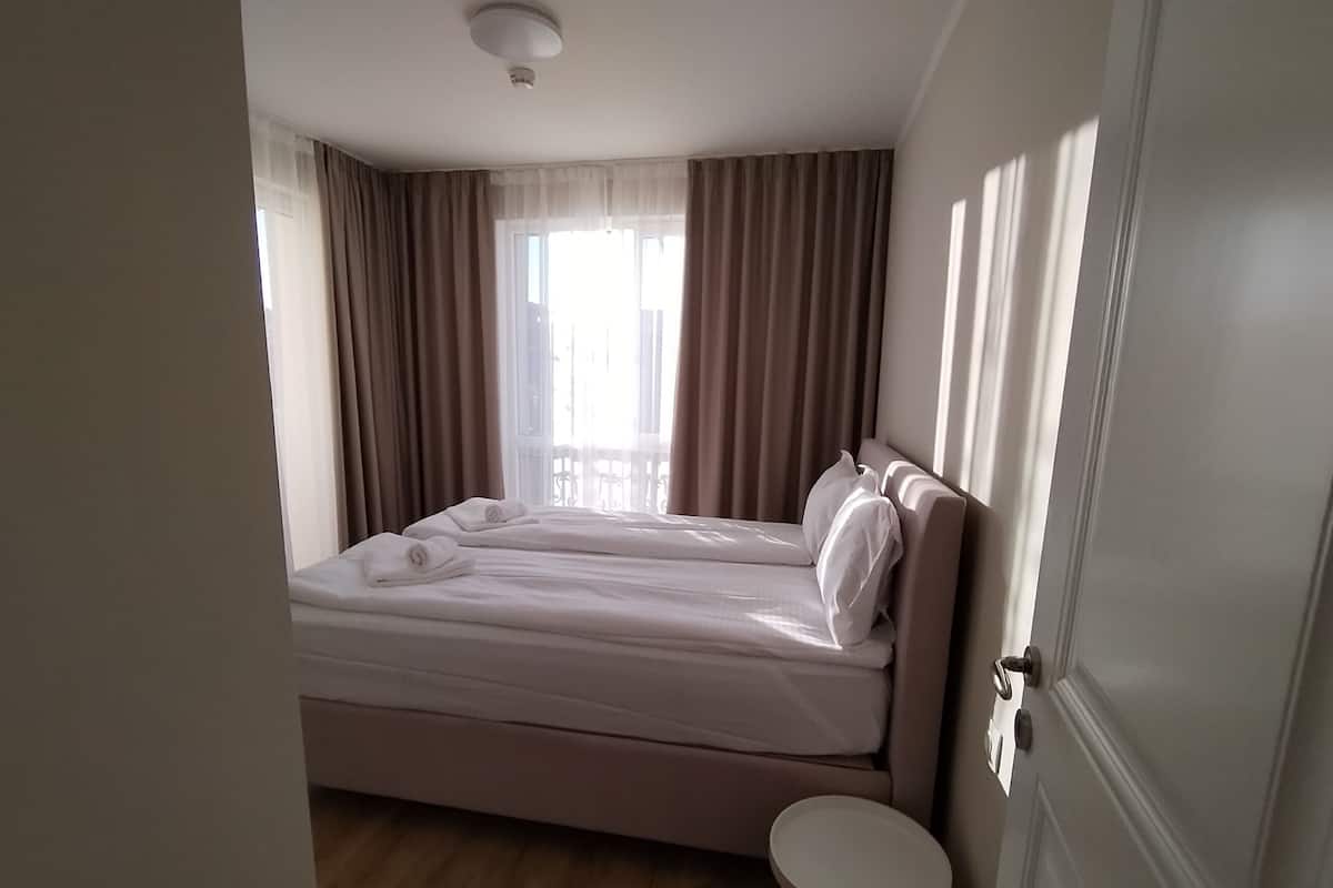 A hotel room with a bed, a small round table, and a door.