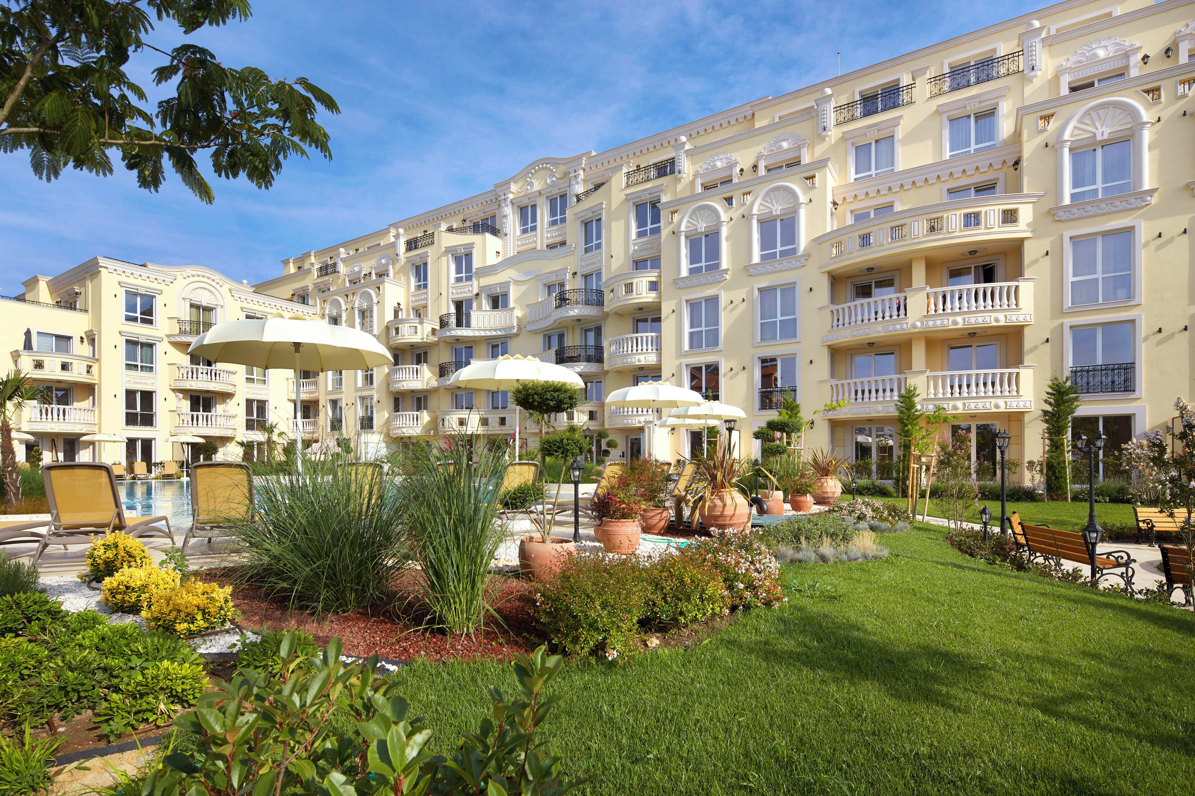 Un hôtel doté de nombreux balcons, d’une piscine et d’un jardin bien entretenu, agrémenté de diverses plantes et d’espaces aménagés pour se détendre.