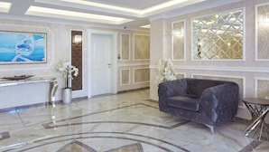 A lobby with a marble floor, a reception desk, a large abstract painting, a sofa, and a decorative window. - Bellicity Apart Complex (Ravda)