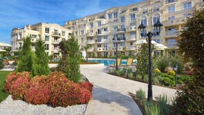 A multi-story hotel with balconies, a swimming pool, and landscaped gardens. - Bellicity Apart Complex (Ravda)