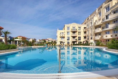 Alberca al aire libre, sombrillas en la alberca y camastros