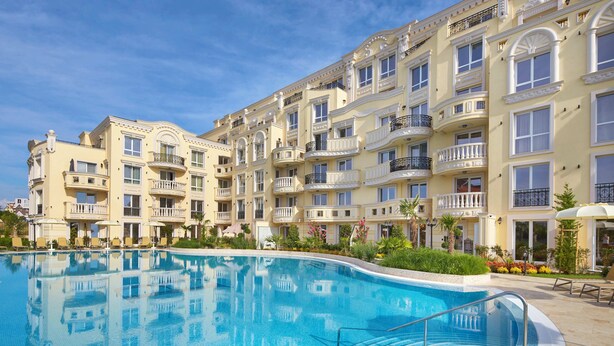 A hotel with a swimming pool, multiple balconies, and a well-maintained garden. - Bellicity Apart Complex (Ravda)