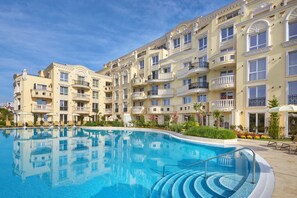 A hotel with a swimming pool, multiple balconies, and a well-maintained garden. - Bellicity Apart Complex (Ravda)