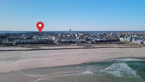 Un paysage urbain côtier avec une plage, des bâtiments et un château d’eau.