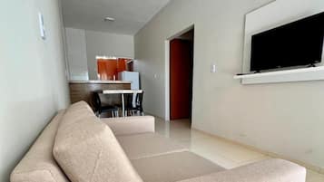 Apartamento luxo, vista para o jardim | Área de estar | TV