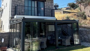 Una casa moderna de dos pisos con un patio envuelto en vidrio.