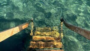 Un bote de madera con una vista clara del entorno submarino.