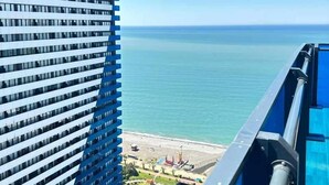A high-rise building with a view of a calm body of water and a distant shoreline. - orbi city 777 (Batumi)