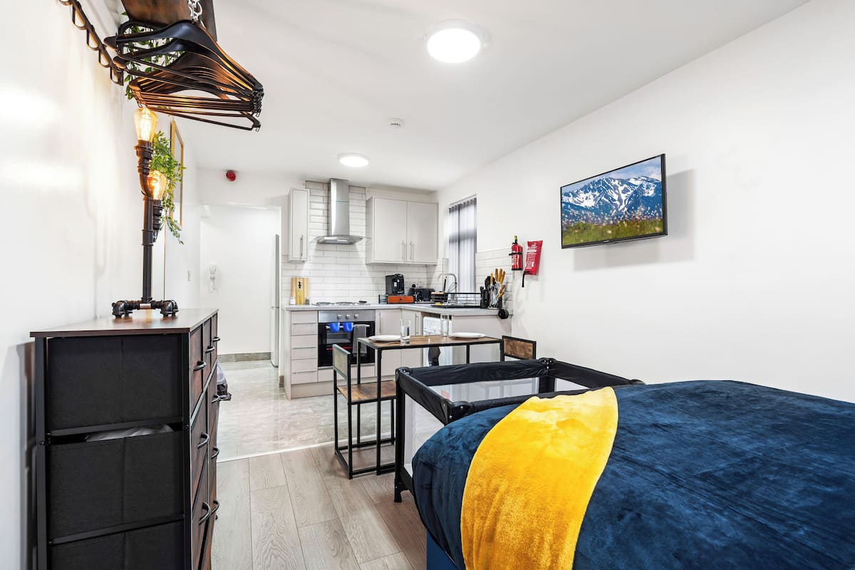 A compact kitchen with white cabinets, a central island, and a dining table.