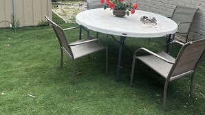 A round table with four chairs, a potted plant, and a small decorative item on the table. - Tiny home for  short and long term also (Sugar Land)