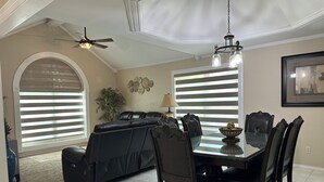 A dining area with a table, chairs, and a ceiling fan.