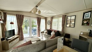A cozy living room with a sofa, a TV, and a dining table.