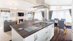 A modern kitchen with a central island, white cabinetry, and a gas stove.