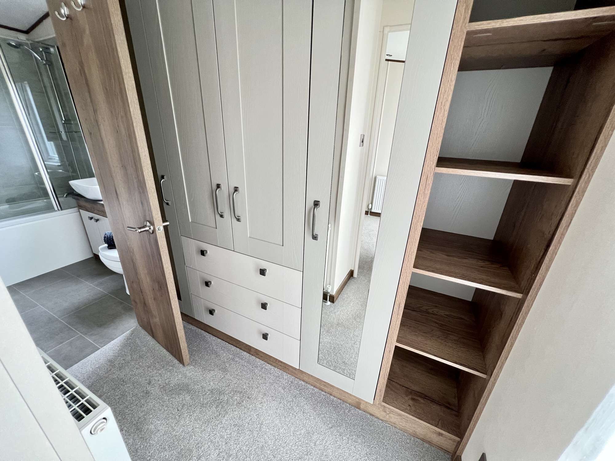 Een badkamer met een ruime inloopkast, toilet en douchehoek.