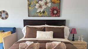 A neatly made bed with a brown duvet, multiple pillows, and two folded towels. - House on the Mesa with 9 beds/Jacuzzi & Pool near JTNP (Yucca Valley)