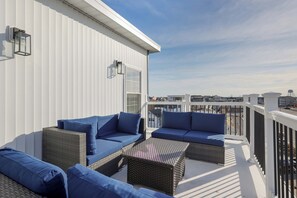 Relax on the balcony with a city view, featuring wicker furniture and a comfortable seating area.