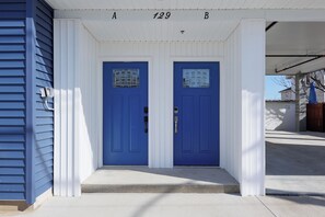 Two entrance doors with white columns and a porch ceiling.