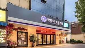 A hotel entrance with a sign indicating it is a 'Rest Comfort Hotel'. - Rest Comfort Hotel (Wenzhou Lucheng) (Wenzhou)