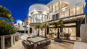 A modern multi-story house with a spacious outdoor patio, a dining area, and a pool. - Villa Seminole: Luxurious Waterfront Retreat with Pool, Gym & Hot Tub (Fort Lauderdale)