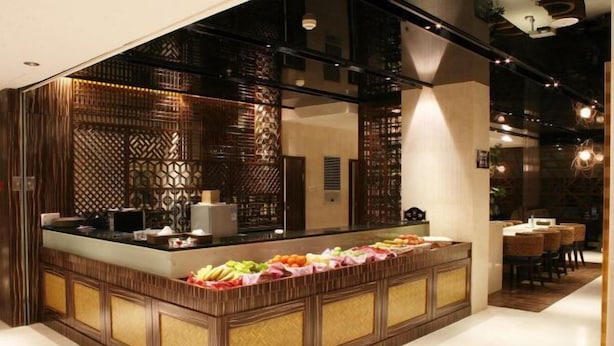 A restaurant with a wooden counter and a variety of fruits displayed. - Ruixin Hotel (Fuqing)