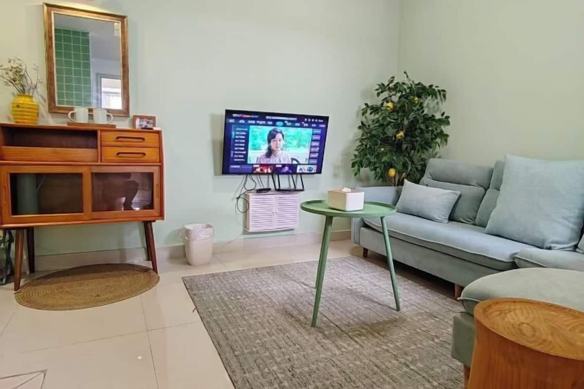 A living room with a television, sofa, and a small table.