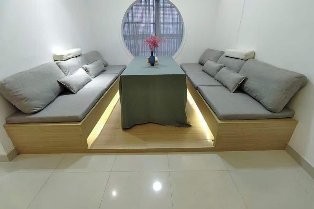 A modern living room with a sofa set, a central table, and a large window.