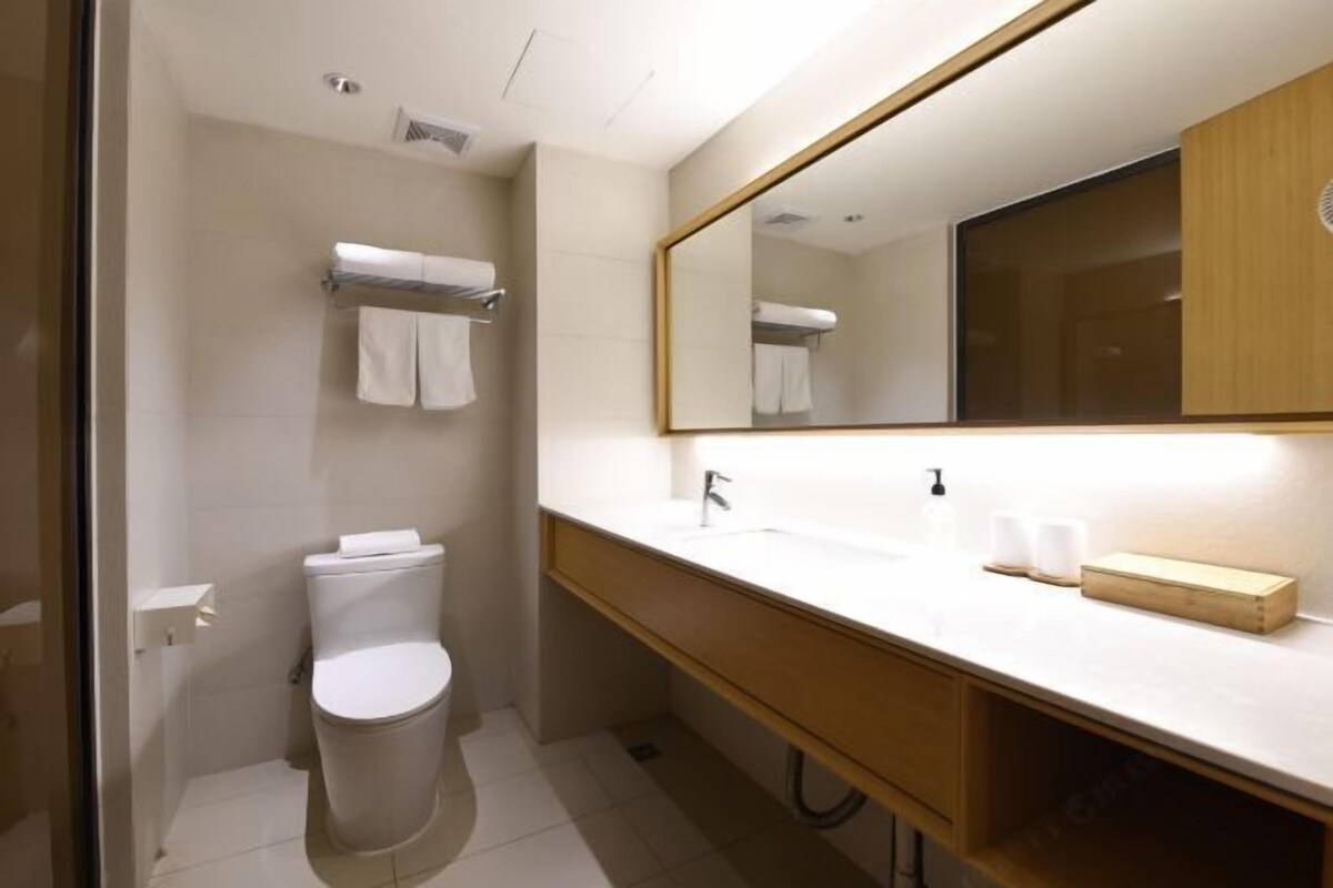 Ein modernes Badezimmer mit Toilette, Waschbecken und Spiegel.