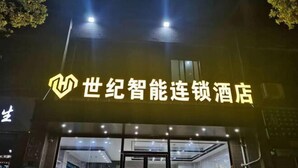 A hotel entrance with illuminated signage and a modern interior visible through the glass doors. - Century Business Hotel (Zuoling New Town) (Wuhan)