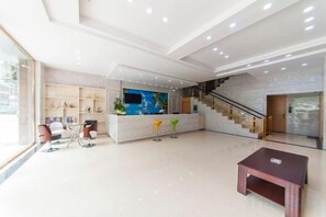 A spacious lobby with a reception desk, seating area, and a staircase. - Century Business Hotel (Zuoling New Town) (Wuhan)