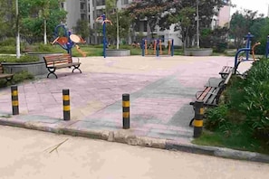 A paved pedestrian area with benches, bollards, and exercise equipment. - Century Business Hotel (Zuoling New Town) (Wuhan)