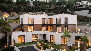 Una casa moderna a due piani con ampie finestre e un tetto piatto.