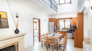Uma sala de jantar ampla com lareira, mesa de madeira e cadeiras.