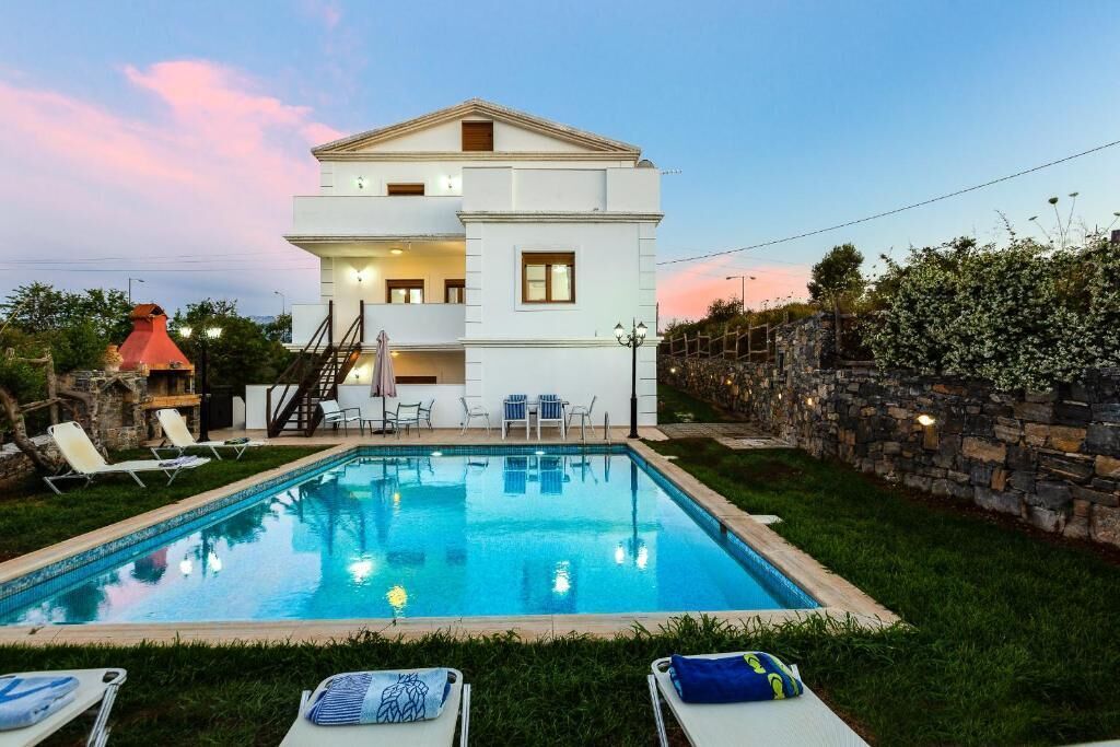 A two-story building with a swimming pool in the foreground.