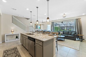 A modern kitchen with granite countertops, a dishwasher, and pendant lighting. - Amazing 5BR house with theme rooms, POOL HEAT INCLUDED (Davenport)