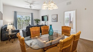 A dining area with a glass table surrounded by wicker chairs, a ceiling fan, and a view of the outdoors. - BB 1016 Huge Updated 3BR unit Marvel room sleeps 8 (Davenport)