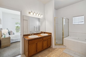 A bathroom with a double sink vanity, a glass shower enclosure, and a large mirror.