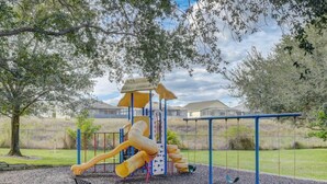 A playground with slides and swings, surrounded by trees and a fence. - BB 1016 Huge Updated 3BR unit Marvel room sleeps 8 (Davenport)
