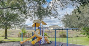 A playground with slides and swings, surrounded by trees and a fence. - BB 1016 Huge Updated 3BR unit Marvel room sleeps 8 (Davenport)