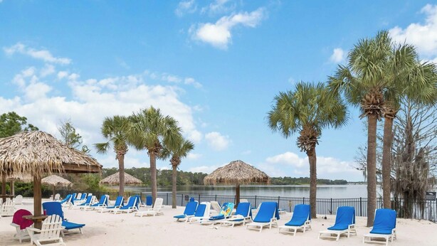 A beach with lounge chairs, thatched umbrellas, and palm trees. - BB 1016 Huge Updated 3BR unit Marvel room sleeps 8 (Davenport)
