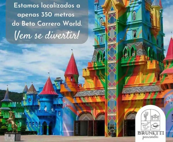 Un bâtiment aux couleurs vives, ressemblant à un château, sur lequel est apposée une enseigne indiquant qu’il se trouve à 350 mètres du parc Beto Carrero World.