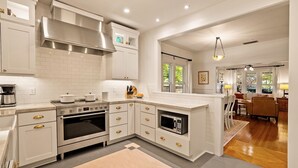 A modern kitchen with white cabinetry, a built-in oven, and a microwave. - Luxury Paso Bungalow • Hot Tub & EV Charger (Paso Robles)