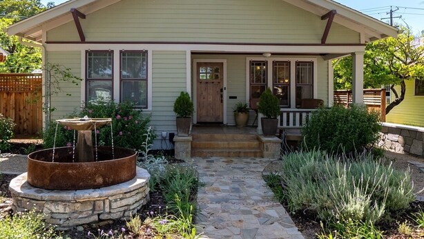 A single-story house with a front porch, a stone fountain, and a well-maintained garden. - Luxury Paso Bungalow • Hot Tub & EV Charger (Paso Robles)