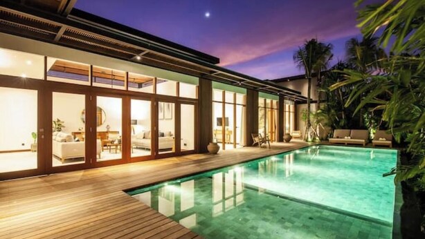 A modern house with a swimming pool, wooden deck, and tropical plants. - Big pool 5 BR Villa Canggu Prime location, 5 min to Berawa beach, . (Tibubeneng)