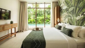 A bedroom with a large bed, a TV on the wall, a console table, and a view of greenery through the window. - Big pool 5 BR Villa Canggu Prime location, 5 min to Berawa beach, . (Tibubeneng)