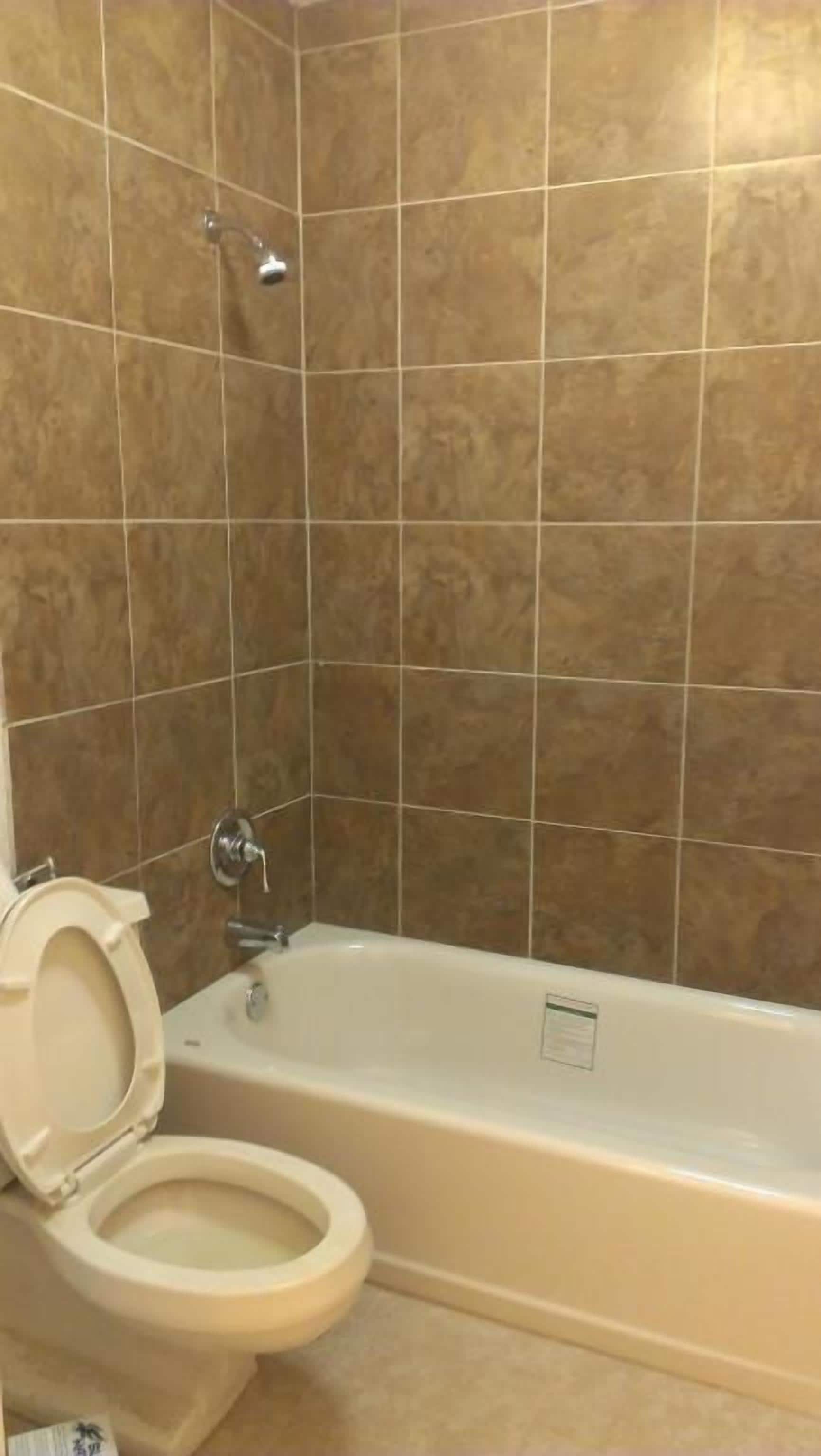 A bathroom with a bathtub, toilet, and shower.