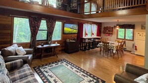 Ein Ferienhausinnenraum mit Schlafzimmer im Erker, Essbereich und Wohnzimmer mit Kamin.