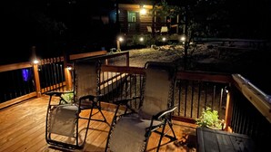 Eine Terrasse im Freien mit Holzboden und Metallstühlen.