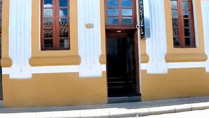 A building with a yellow facade, white trim, and a sign indicating it is a hotel. - Hotel victoria Real (Tunja)
